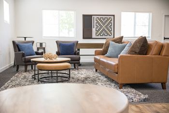 A living room with a brown leather couch and a coffee table in the center.